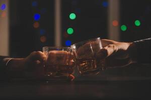 fête nuit, verser whisky dans une verre. donner à copains qui viens à célébrer photo