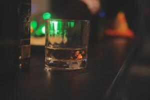 fête nuit, verser whisky dans une verre. donner à copains qui viens à célébrer photo