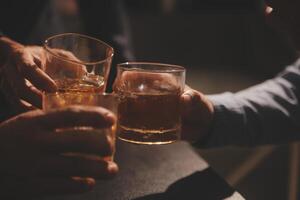 fête nuit, verser whisky dans une verre. donner à copains qui viens à célébrer photo