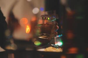 fête nuit, verser whisky dans une verre. donner à copains qui viens à célébrer photo