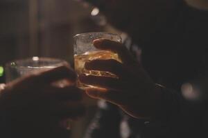 fête nuit, verser whisky dans une verre. donner à copains qui viens à célébrer photo