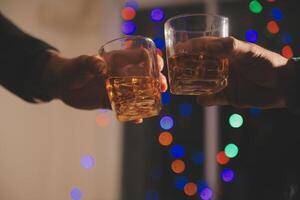 fête nuit, verser whisky dans une verre. donner à copains qui viens à célébrer photo