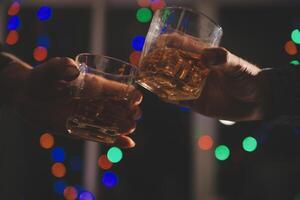 fête nuit, verser whisky dans une verre. donner à copains qui viens à célébrer photo