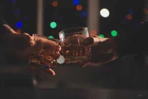 fête nuit, verser whisky dans une verre. donner à copains qui viens à célébrer photo