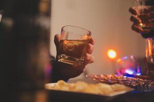 fête nuit, verser whisky dans une verre. donner à copains qui viens à célébrer photo