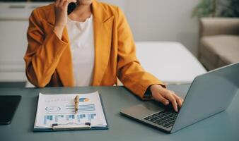 femme d'affaires asiatique en costume formel au bureau heureuse et joyeuse lors de l'utilisation d'un smartphone et du travail photo