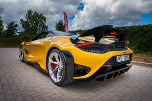 vibrant Jaune McLaren 765 litres, élevé aile, dans un Extérieur scénique réglage photo