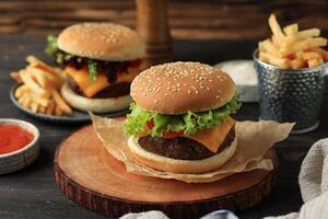 fait maison savoureux Burger avec fromage, du boeuf galettes, tomate, et salade photo