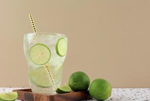 rafraîchissant citron vert un soda avec la glace cube dans grand verre avec papier paille photo