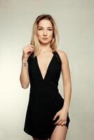 portrait de magnifique blond femme dans noir robe. mode photo