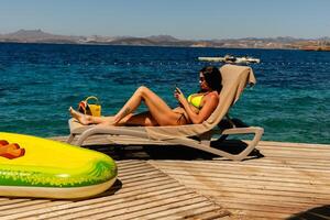 Jeune sexy fille dans une lumière vert bikini sur le océan photo