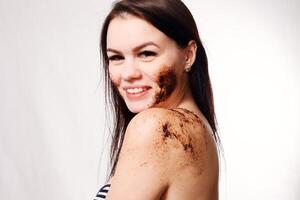brunette femme nettoie le peau de le corps café frotter photo