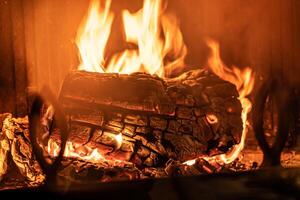 Journal de bois brûlant dans une cheminée à l'intérieur une loger, foyer photo
