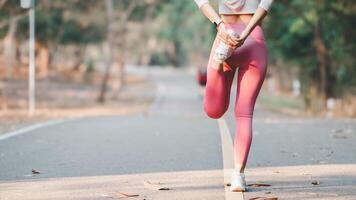 aptitude concept, une concentré femelle coureur performant une quad étendue dans préparation pour une faire du jogging sur une ensoleillé parc route. photo