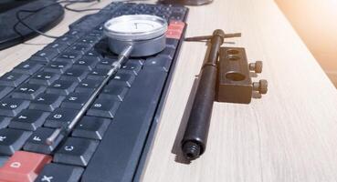 cadran ennuyer jauge et clavier ordinateur sur le bois table pour La technologie de mesure outils concept. photo