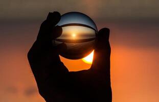 cristal dans main à le coucher du soleil. photo