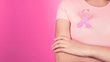 soins de santé, personnes, charité et médicament concept - proche en haut de femme dans T-shirt avec Sein cancer conscience ruban plus de rose Contexte photo