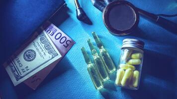 drogues sont opiacés dans pilules et ampoules. argent, pilules et une stéthoscope sur le table fermer. pots-de-vin et Audit concept photo