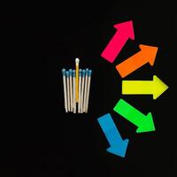 multicolore allumettes sur une noir Contexte avec flèches symbolisant le droite à choisir. inclusion. photo