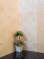 bouquet en plastique dans un vase décorer le coin du mur dans la douche photo