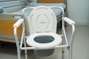 toilettes à chasse d'eau et chaise de douche dans la salle de bain pour personnes âgées. photo