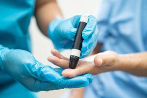 médecin vérifier Diabète de doigt du sang sucre niveau avec doigt lancette. photo