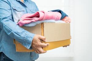 boîte de dons avec des vêtements usagés à la maison pour soutenir l'aide aux pauvres dans le monde. photo