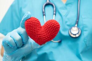 médecin tenant un coeur rouge dans la salle d'hôpital, concept médical solide et sain. photo