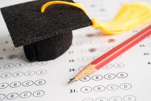 chapeau d'écart de graduation et crayon sur fond de feuille de réponses, étude de l'éducation testant l'apprentissage enseigner le concept. photo