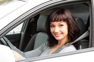 content propriétaire de une Nouveau voiture souriant à toi. jolie fille chauffeur photo