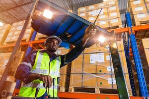 africain noir Masculin Personnel ouvrier travail contrôle chargement fonctionner chariot élévateur dans entrepôt inventaire usine photo