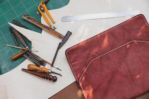 fermer main outil pour cuir tailleur fabricant. vieux artisanat Maître pièce travail équipements. photo