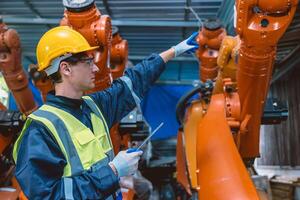 professionnel ingénieur Masculin caucasien travail avec automatique robotique bras pour moderne industrie usine La technologie photo