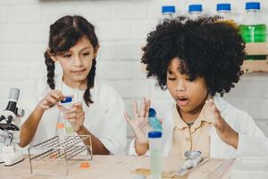 Jeune les enfants en jouant passionnant avec chimie science kits dans école salle de cours avec ami classe camarade photo