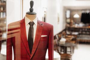 rouge costume à tailleur vitrine. gentilhomme vêtements sur mannequin afficher à costume Couper sur mesure tailleur. photo