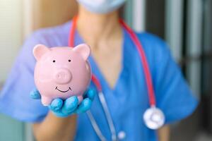 médical Personnel main montrant porcin banque sourire pour économie argent pour futur soins de santé santé Assurance concept photo