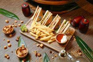 en bois Coupe planche avec moitié sandwich et français frites photo