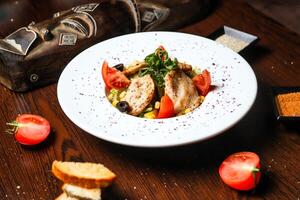 blanc assiette avec délicieusement surmonté Viande et des légumes photo