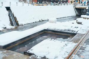 pied une baignoire chaud printemps dans ginzan onsen avec neige tomber dans hiver saison est plus célèbre Japonais chaud printemps dans Yamagata, Japon. photo