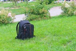 du photographe sac à dos sur une vert pelouse avec herbe. photo