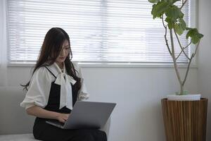 une travail Japonais femme par éloigné travail dans le Accueil Bureau fermer photo