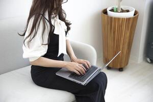 une Japonais femme dactylographie portable par éloigné travail dans le Bureau sans visage composition photo