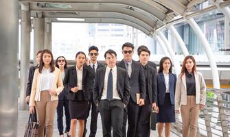 groupe de content Jeune asiatique affaires équipe, hommes d'affaires en marchant le Extérieur Bureau ensemble Succès travail en équipe pour concepts photo