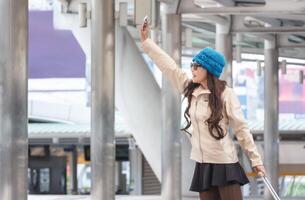 Jeune femelle voyageur avec une valise à le moderne transport Arrêtez en plein air photo