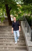 aux cheveux gris Jeune homme avec une sac à dos va vers le bas le escaliers dans le parc. haute qualité photo