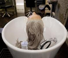 fille dans une beauté salon. laver cheveux, cheveux se soucier, santé. cheveux la lessive processus dans une coiffeur. haute qualité photo