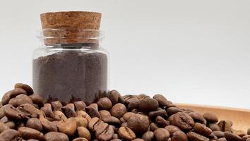 café des haricots sol dans une café broyeur, mortier ou moulin dans une petit verre pot sur le tableau. grossier ou moyen moudre sont emballé pour stockage. une boisson fabriqué de rôti et sol céréales. photo