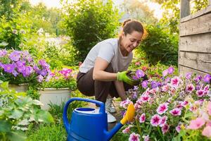 jardinage et agriculture concept. Jeune femme ferme ouvrier jardinage fleurs dans jardin. jardinier plantation fleurs pour bouquet. été jardinage travail. fille jardinage à Accueil dans arrière-cour photo