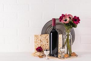 une magnifique de fête arrangement pour le juif Pâque vacances. une bouteille de rouge vin, matsot , une coup de kascher vin, noix. une copie espace. photo