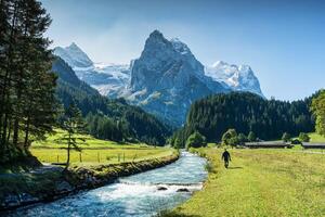 vue de rosenlaui avec Masculin touristique en marchant le long de reichenbach rivière et Wetterhorn glacier Montagne à Berne, Suisse photo